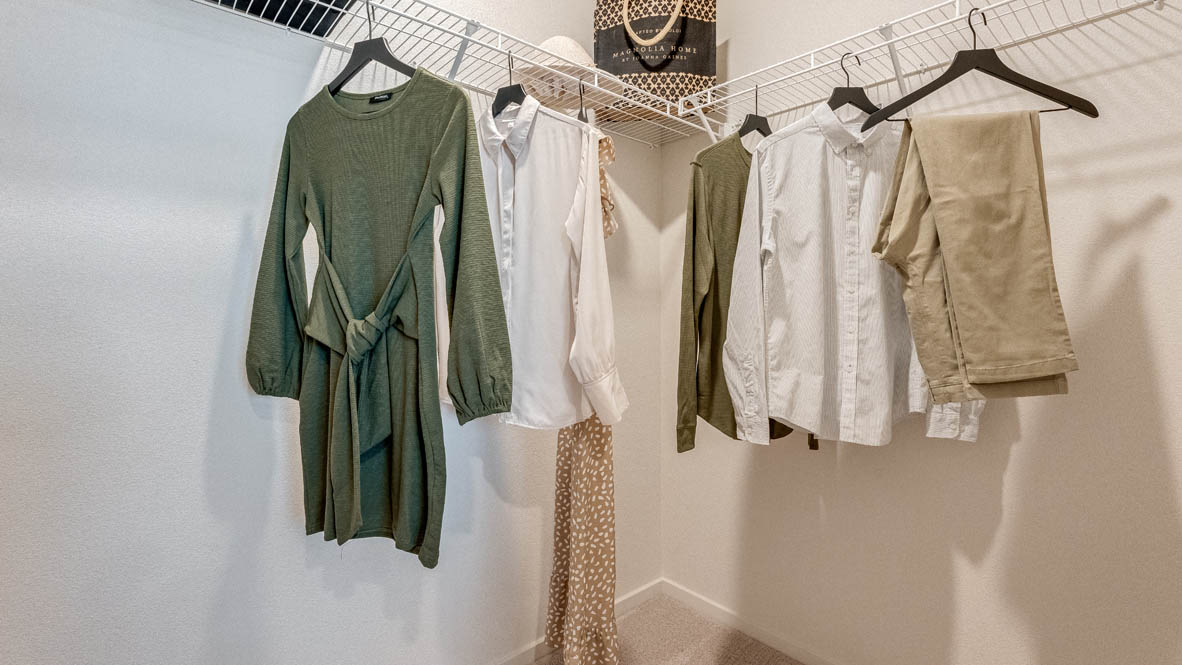 East Park Village laundry room with hamper, paintings, white wire shelving with organizers