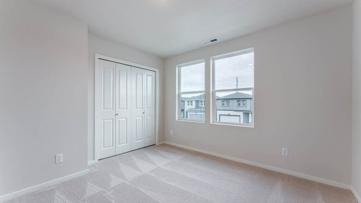 East Park Village bedroom with carpet, windows, and white walls