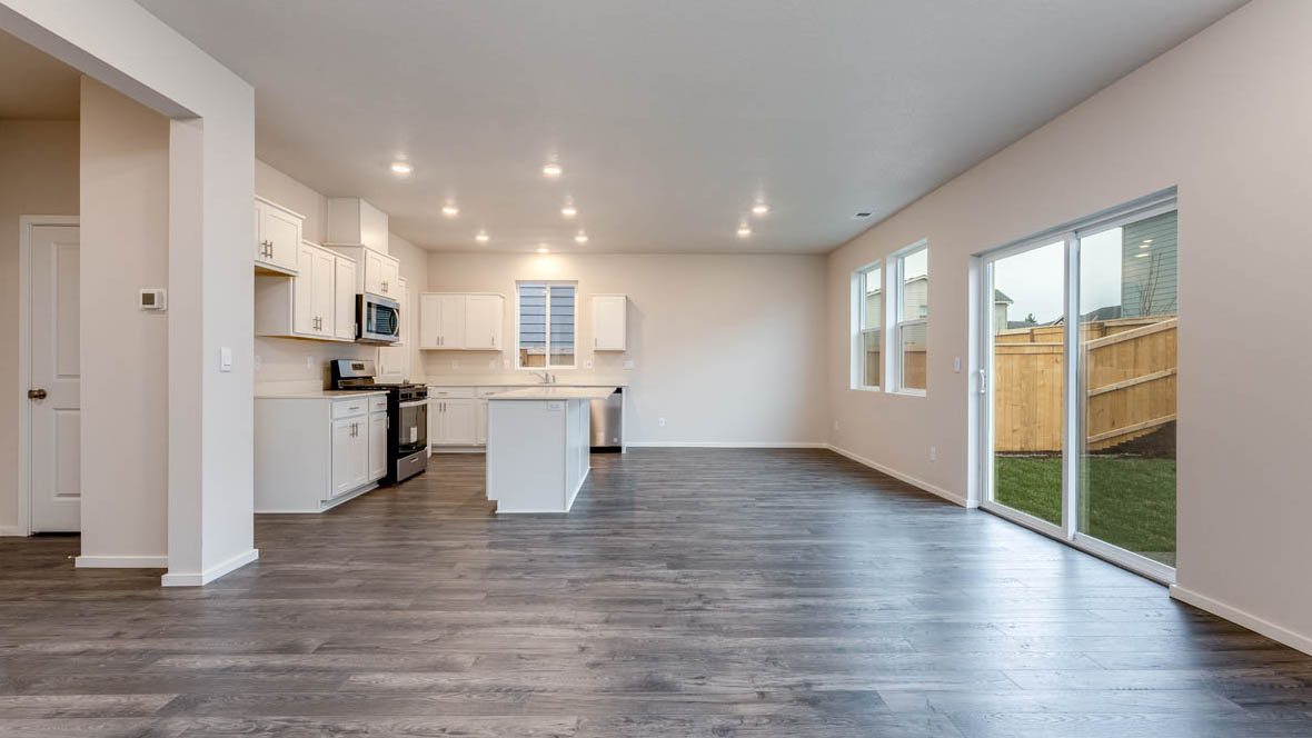 East Park Village dining room with island, laminate flooring, and kitchen in the background