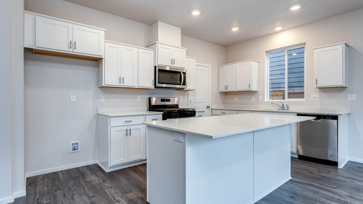 East Park Village kitchen with stainless steel appliances, island, window, cabinets, and laminate flooring