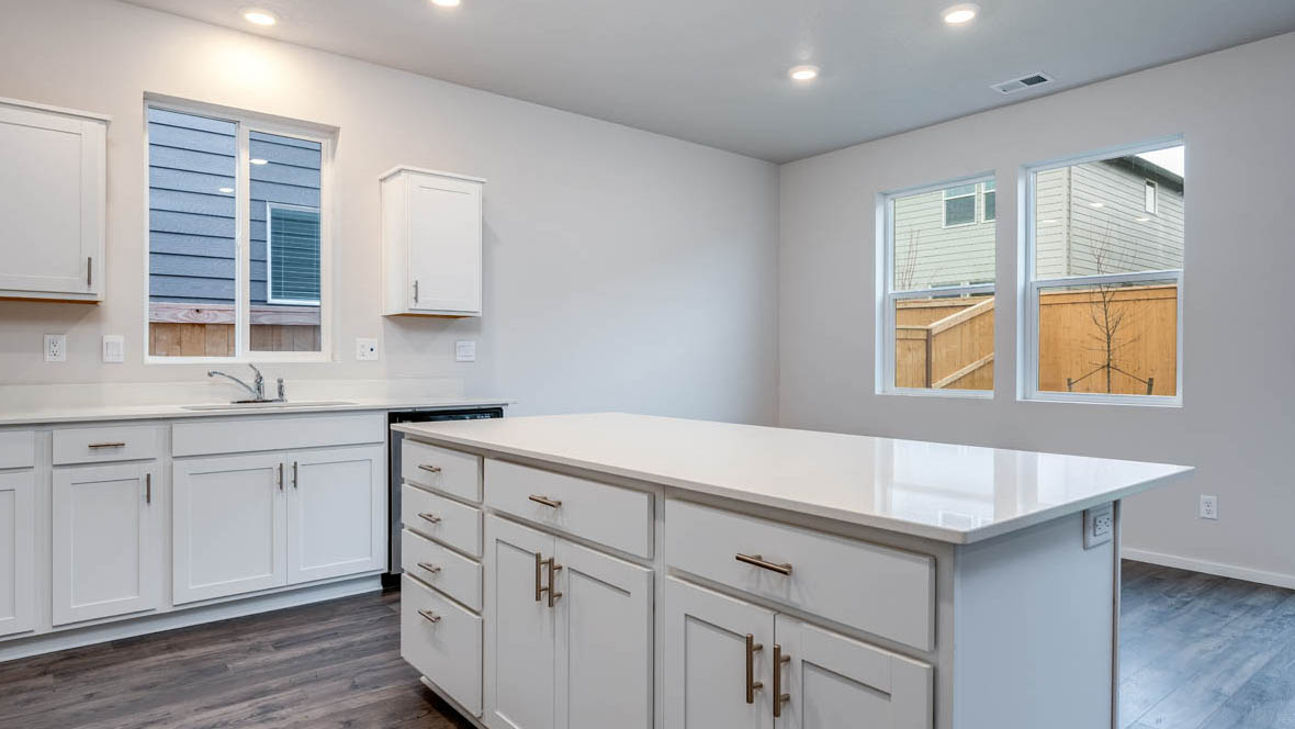 East Park Village kitchen with stainless steel appliances, island, window, cabinets, and laminate flooring