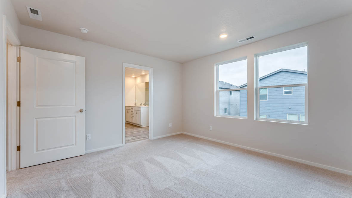 East Park Village Primary bedroom with carpet, windows, and white walls