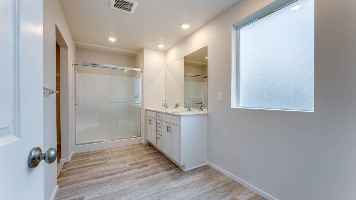 East Park Village Primary Bathroom with laminate flooring, window, walk in shower, vanity