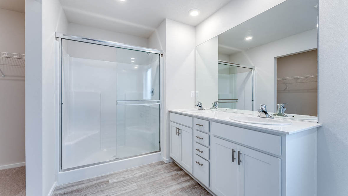 East Park Village Primary Bathroom with laminate flooring, window, walk in shower, vanity