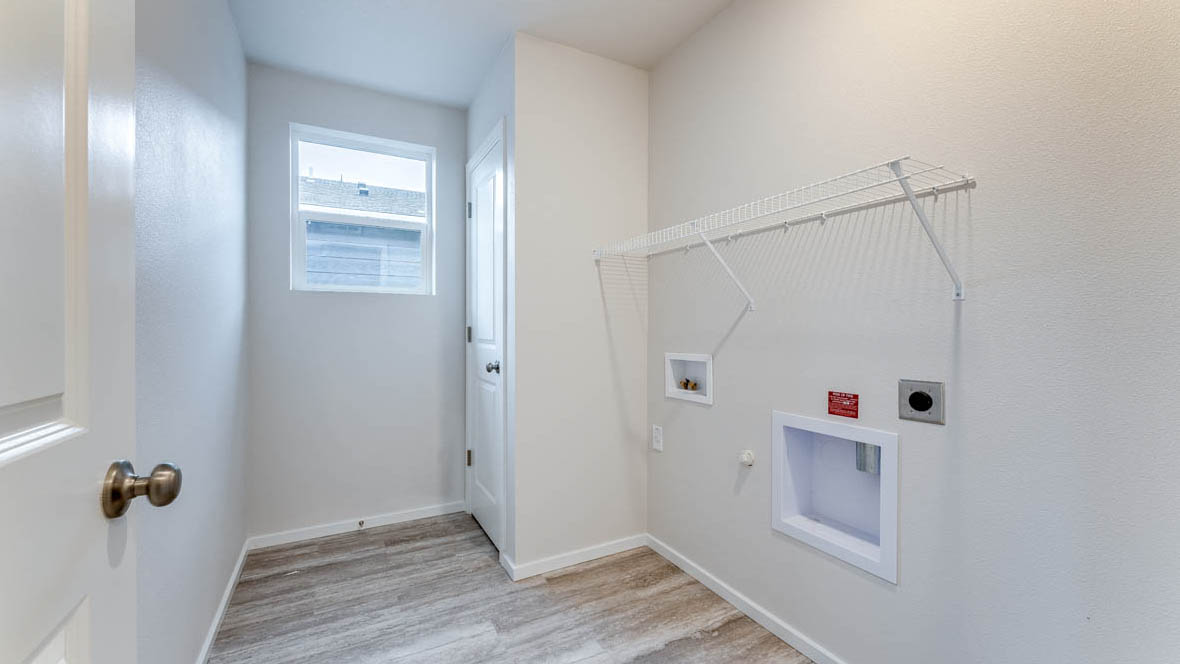 East Park Village Laundry room with window, white walls, and white wire shelving