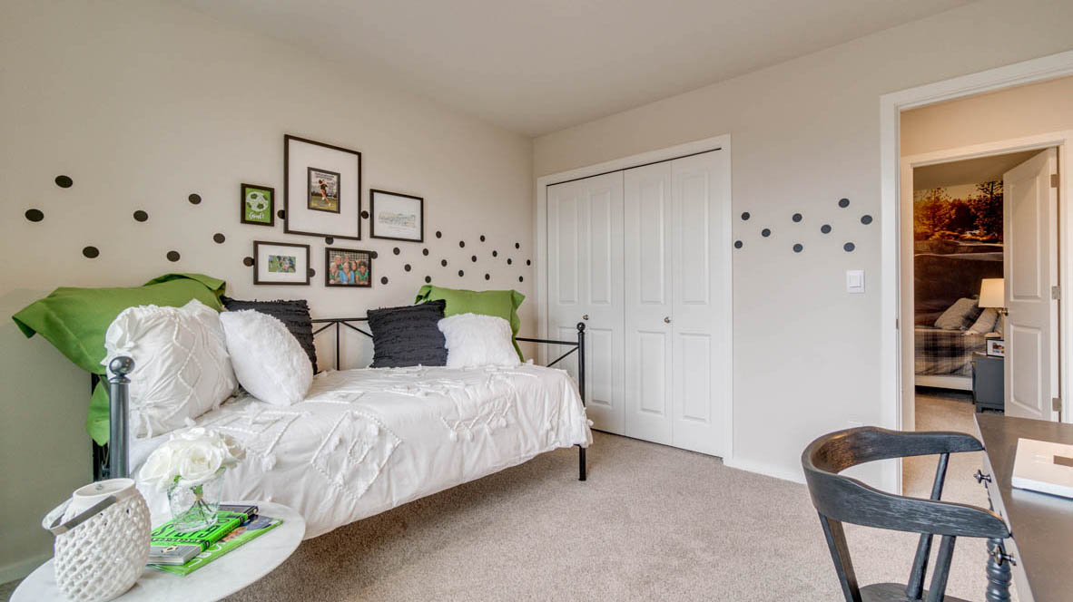 East Park Village Bedroom with day bed, desk, green accents, and painted polka dots in the middle of the walls