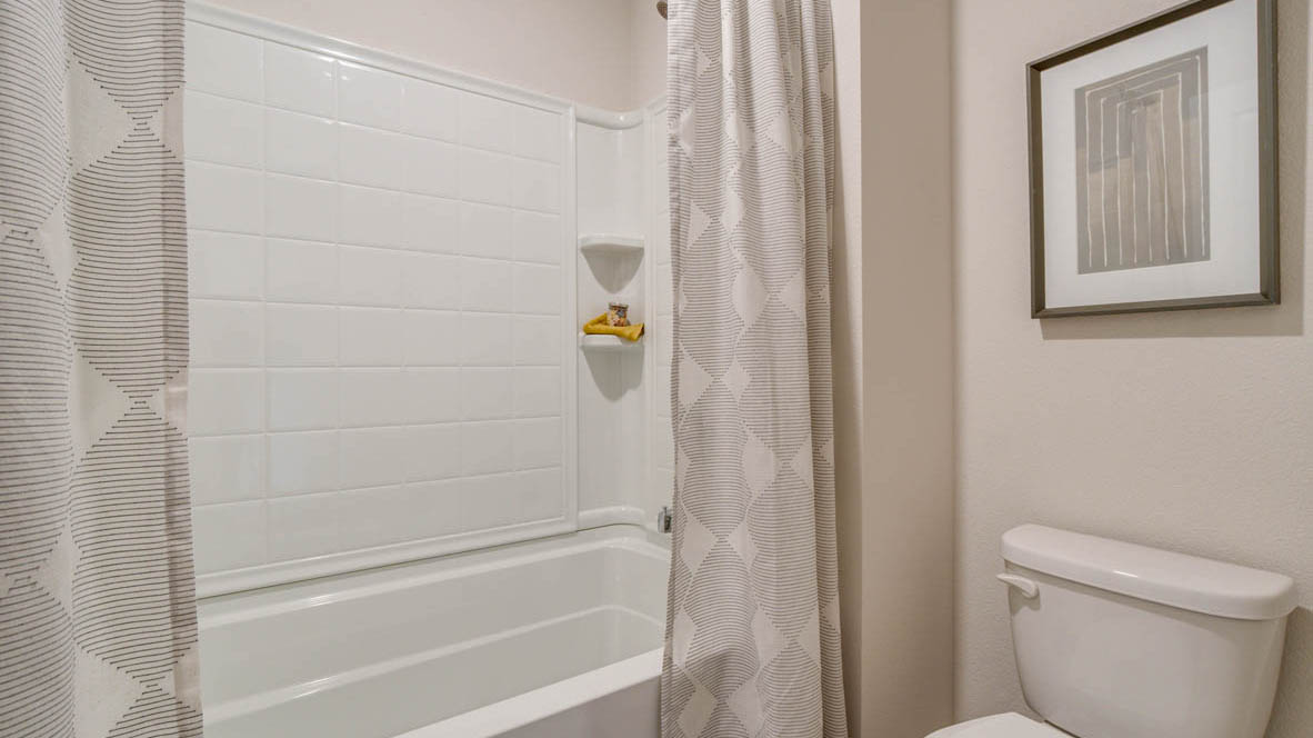 East Park Village Secondary bathroom with single sink vanity, tub shower, and toilet room separated from sink room