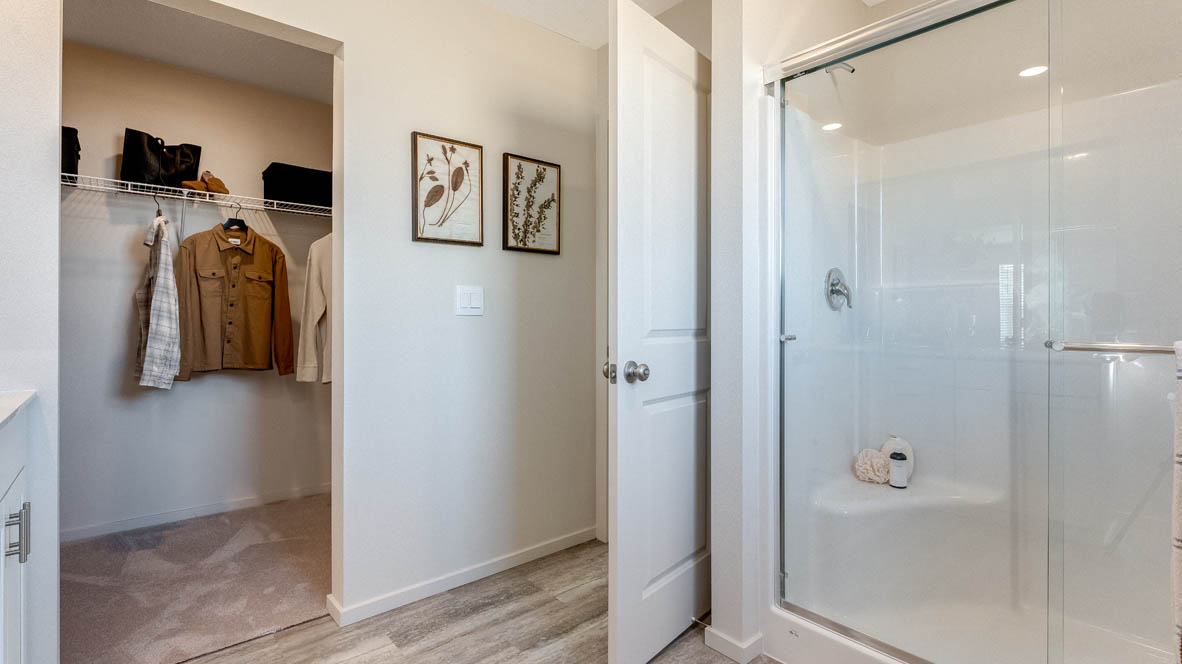 East Park Village primary bathroom and  walk in closet with white wire shelving