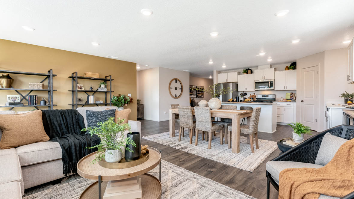 East Park Village Great room with carpet, laminate flooring, windows, couch, coffee table, single chair with end piece, fireplace, tv, and decorative plants with view of dining room and kitchen