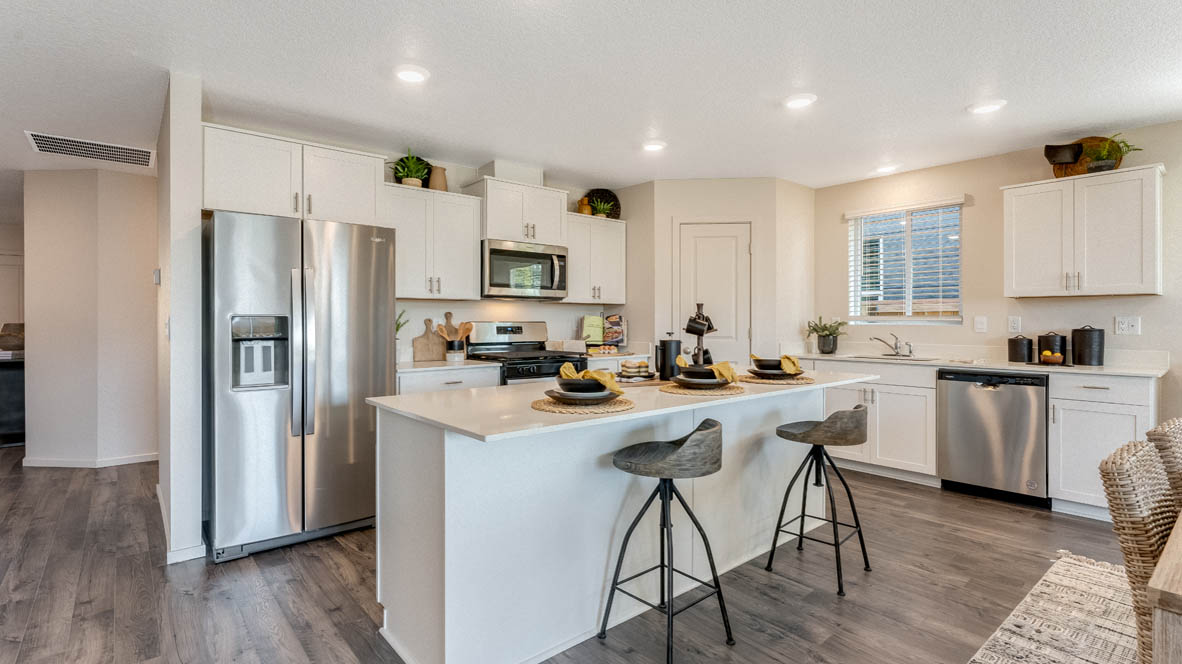 East Park Village Kitchen with quartz countertops, white cabinets, windows, pantry, and view of dining room, and great room