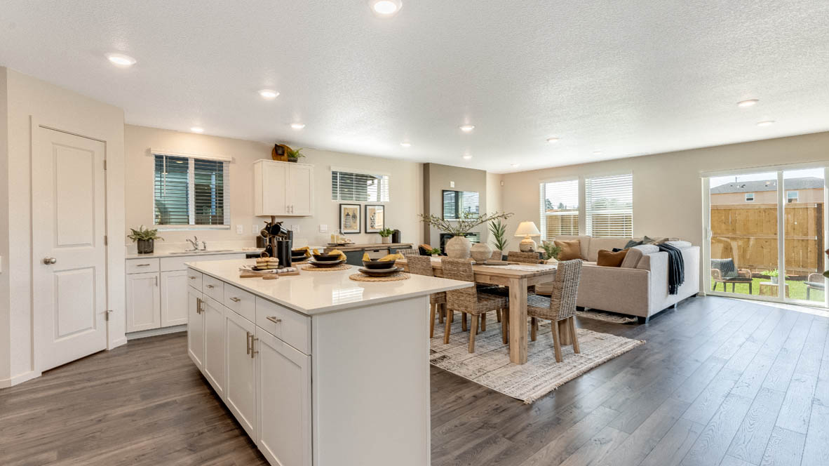 East Park Village kitchen and great room with fireplace, laminate flooring, white cabinets, and solid surface coumtertops