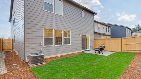 Misty Meadows backyard with concrete patio and grass landscaping
