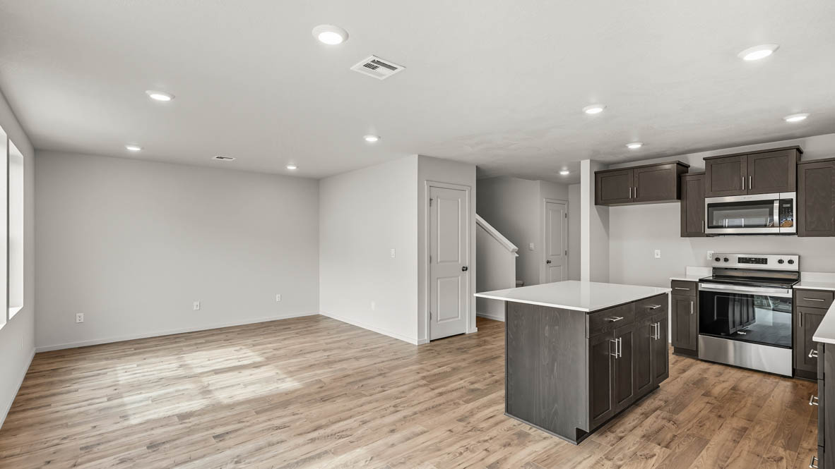 Addysen Park Kitchen and great room with laminate flooring, painted white walls, stainless steel appliances, kitchen island, countertops, cabinets