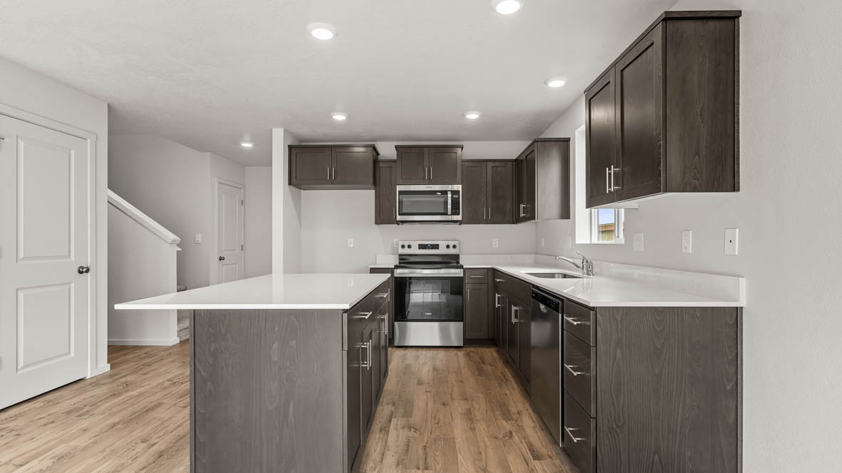 Addysen Park Kitchen with laminate flooring, painted white walls, window. stainless steel appliances, kitchen island, countertops, cabinets