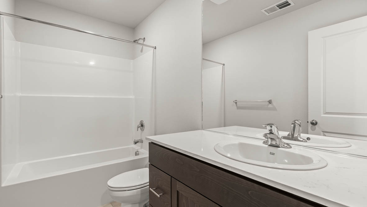 Addysen Park Secondary Bathroom with solid surface countertops, shower tub, mirror, toilet
