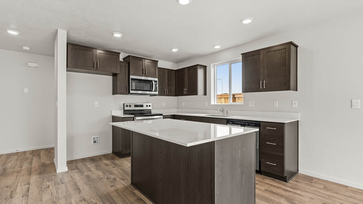 Addysen Park Kitchen with laminate flooring, painted white walls, window. stainless steel appliances, kitchen island, countertops, cabinets