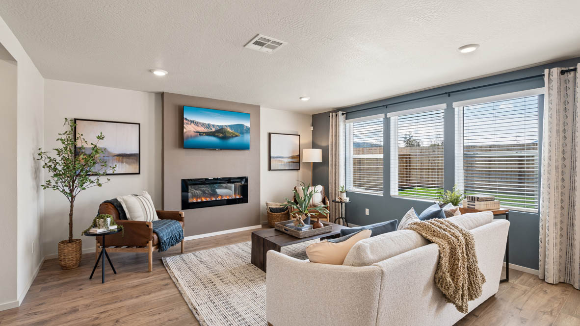 Addysen Park great room with gray accent wall, fireplace with beige paint, white couch, and chairs