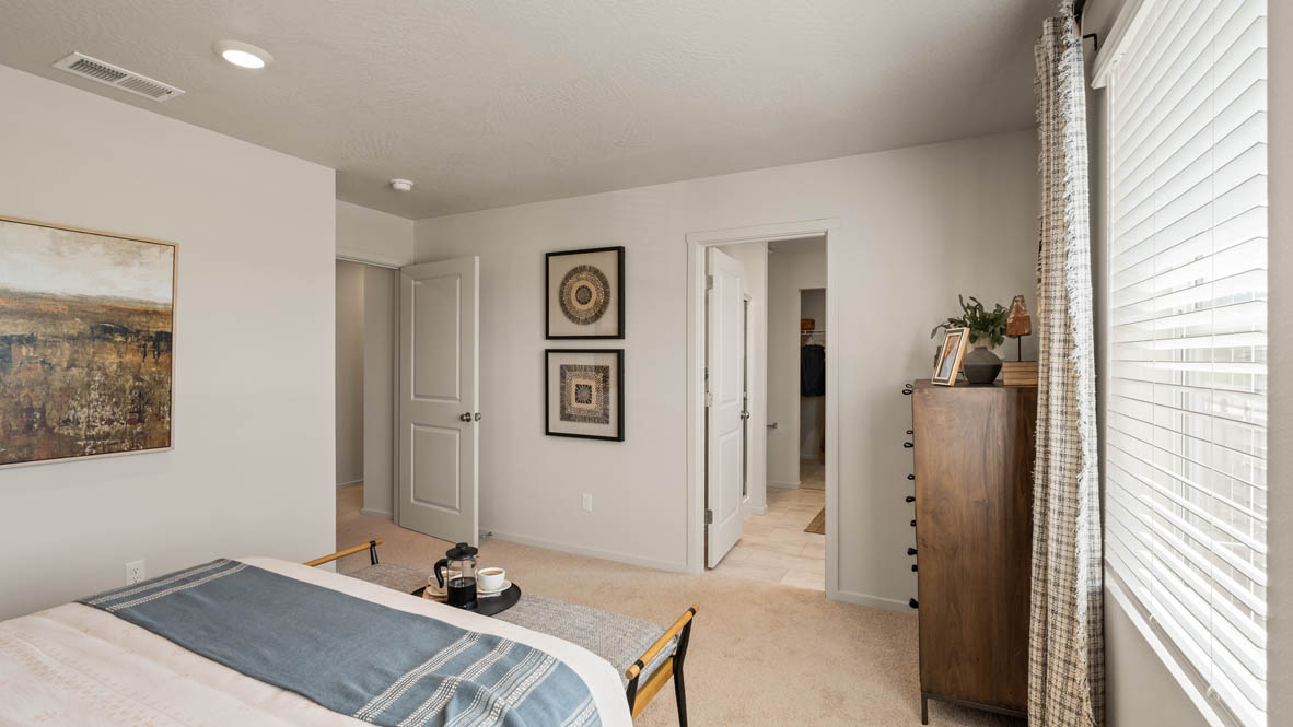 Addysen Park primary bedroom with leather headboard yellow accent wall and brown furniture