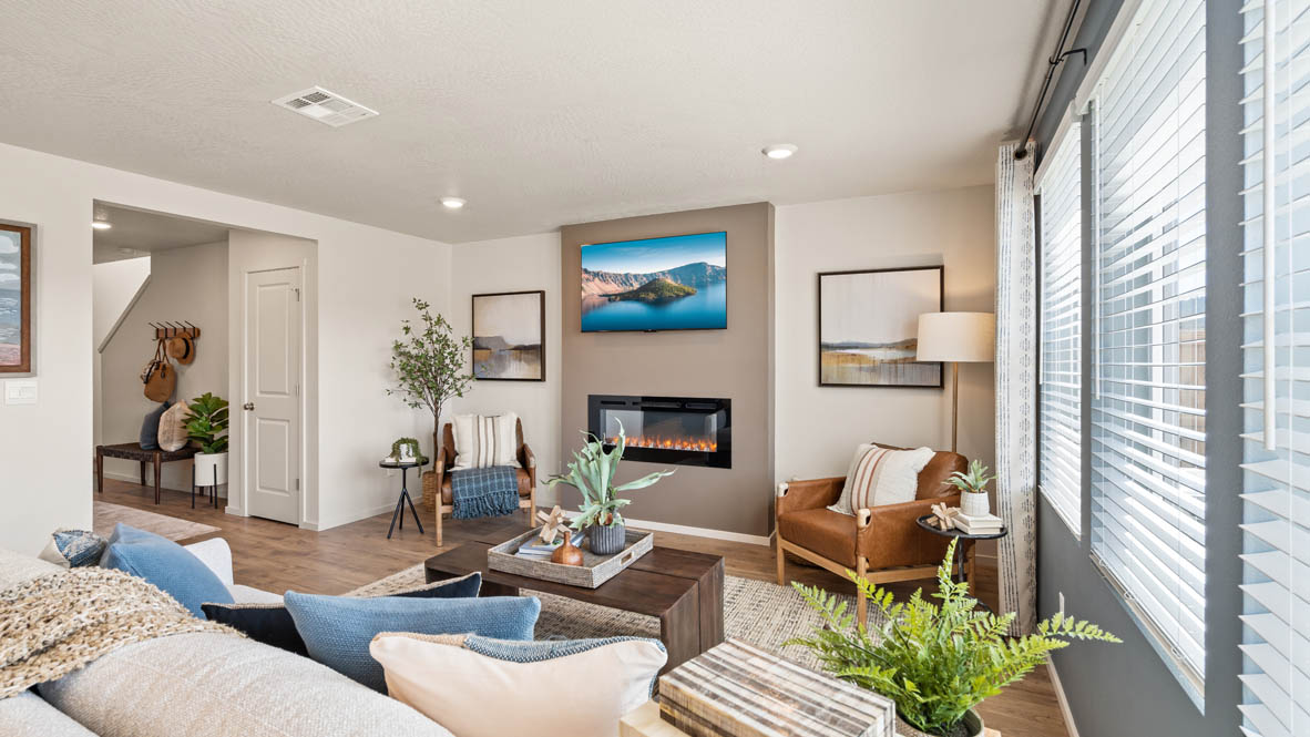 Addysen Park great room with gray accent wall, fireplace with beige paint, white couch, and chairs