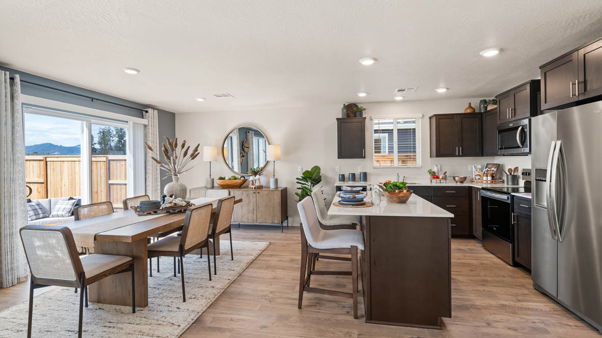 Addysen Park kitchen with brown wood cabinets, a kitchen island, stainless steel appliances, and two barstool chairs