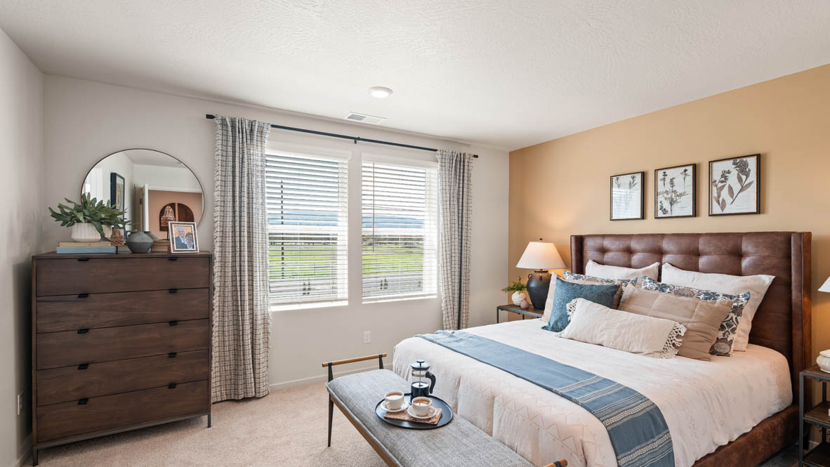 Addysen Park primary bedroom with leather headboard yellow accent wall and brown furniture
