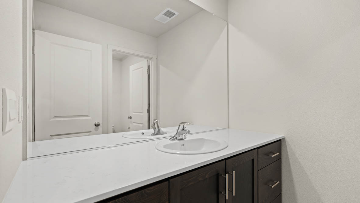Addysen Park bathroom with solid surface countertops, mirror, and cabinets