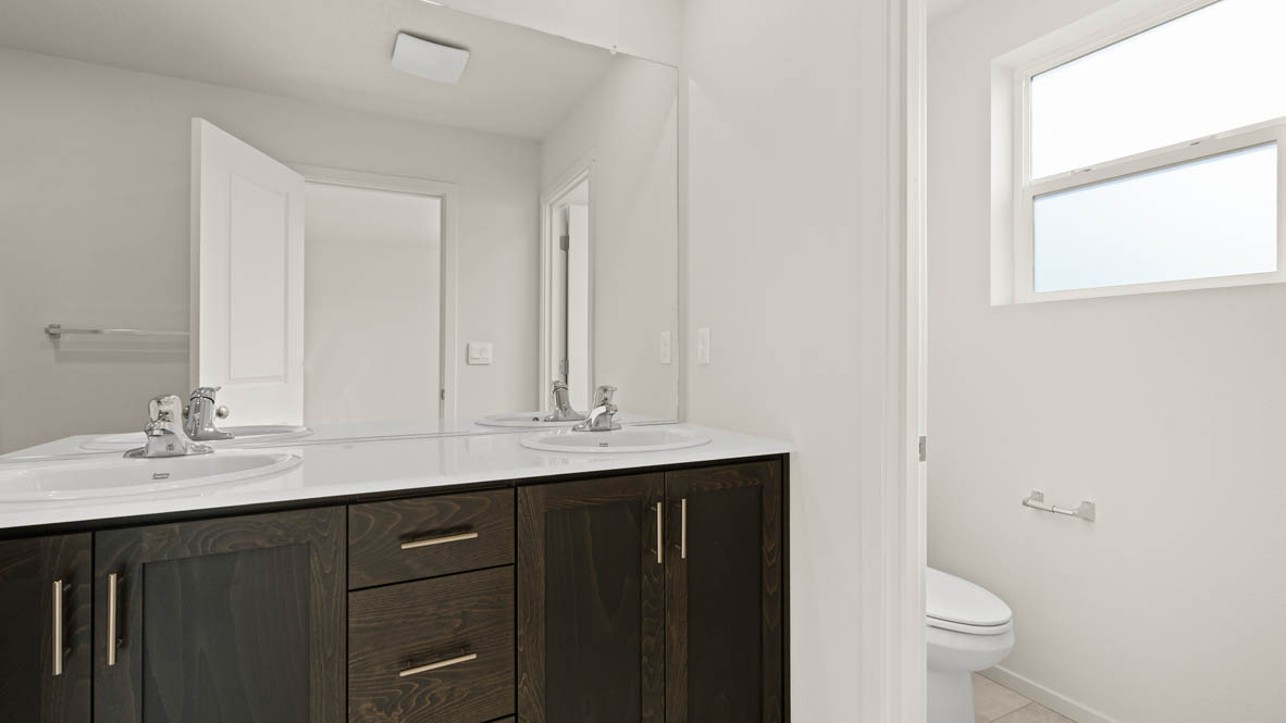 Addysen Park primary bathroom with solid surface countertops, mirror, walk in shower, and cabinets