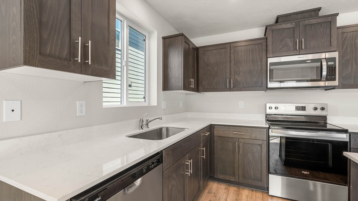 Addysen Park kitchen with laminate flooring, stainless steel appliances, cabinets, window, solid surface countertops