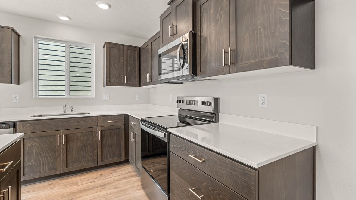 Addysen Park kitchen with laminate flooring, stainless steel appliances, cabinets, window, solid surface countertops