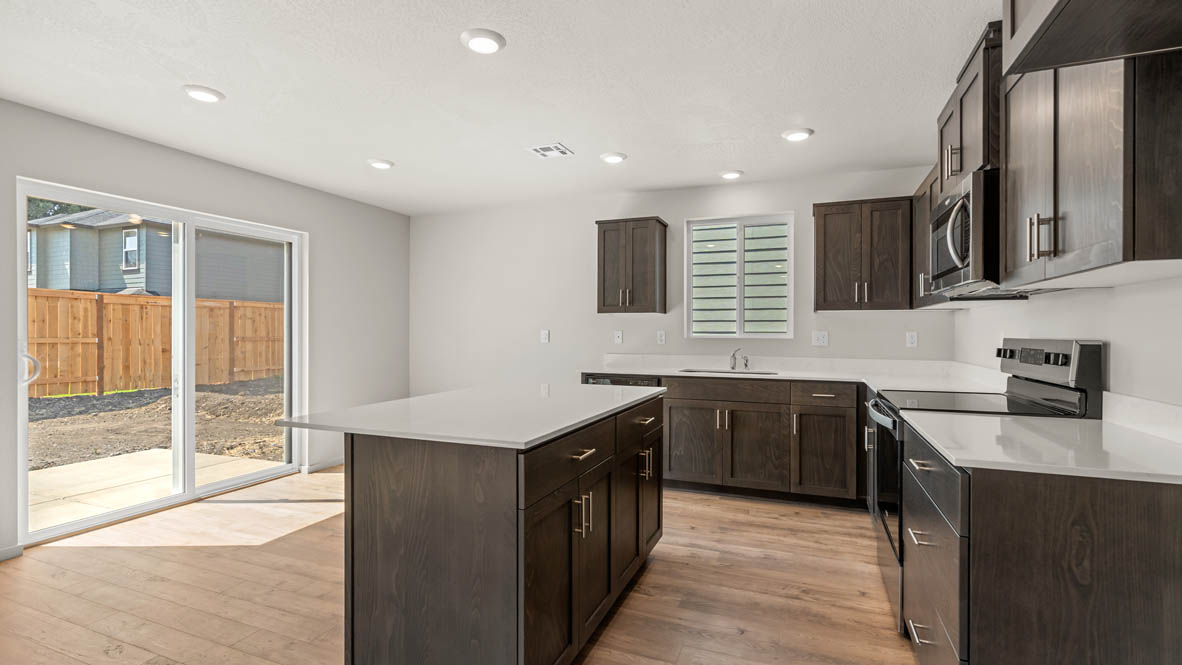 Addysen Park kitchen with laminate flooring, stainless steel appliances, cabinets, window, solid surface countertops