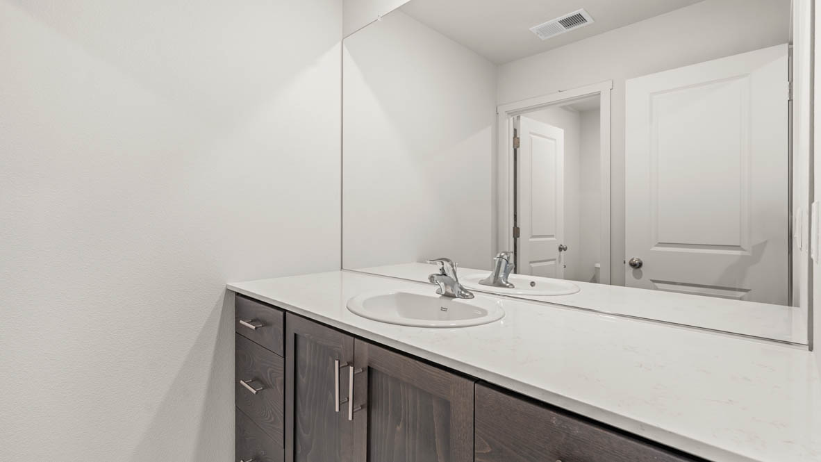 Addysen Park bathroom with solid surface countertops, mirror, and cabinets