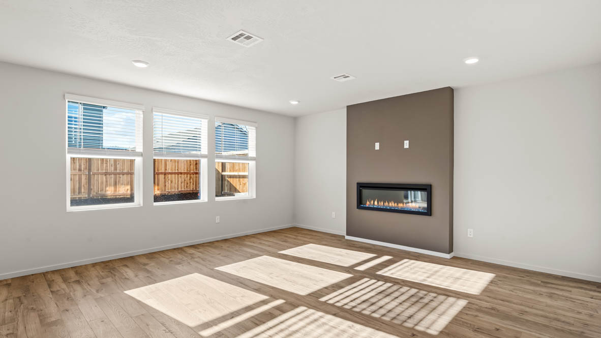 Addysen Park Great room with white walls, windows, fireplace, and laminate flooring