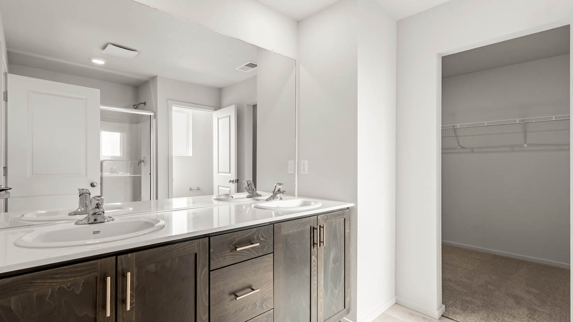 Addysen Park Primary Bathroom with double vanity, walk in shower with sliding glass door, quartz countertops, mirror