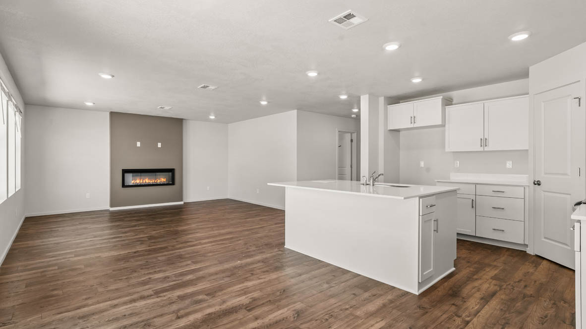 Addysen Park kitchen and Great room with white walls, windows, fireplace, and laminate flooring