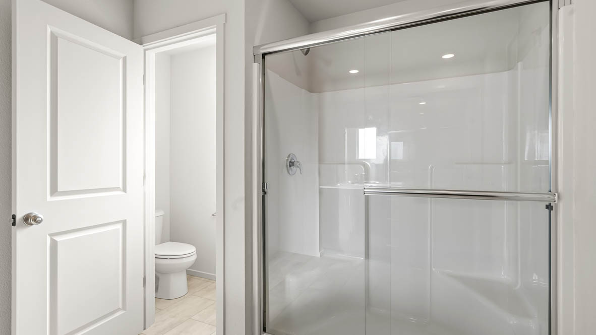 Addysen Park Primary Bathroom with double vanity, walk in shower with sliding glass door, quartz countertops, mirror