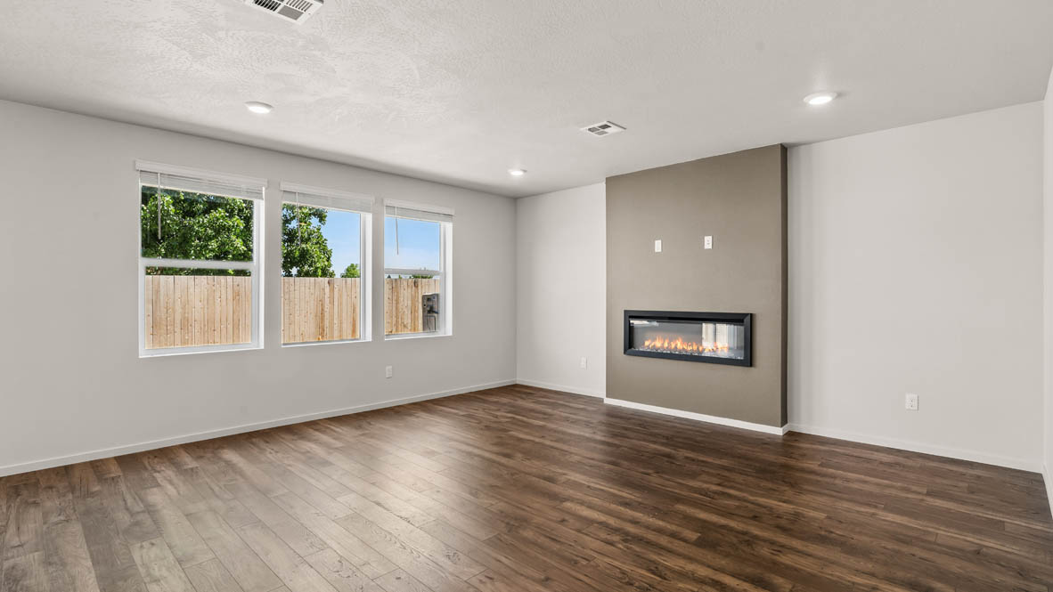 Addysen Park Great room with white walls, windows, fireplace, and laminate flooring