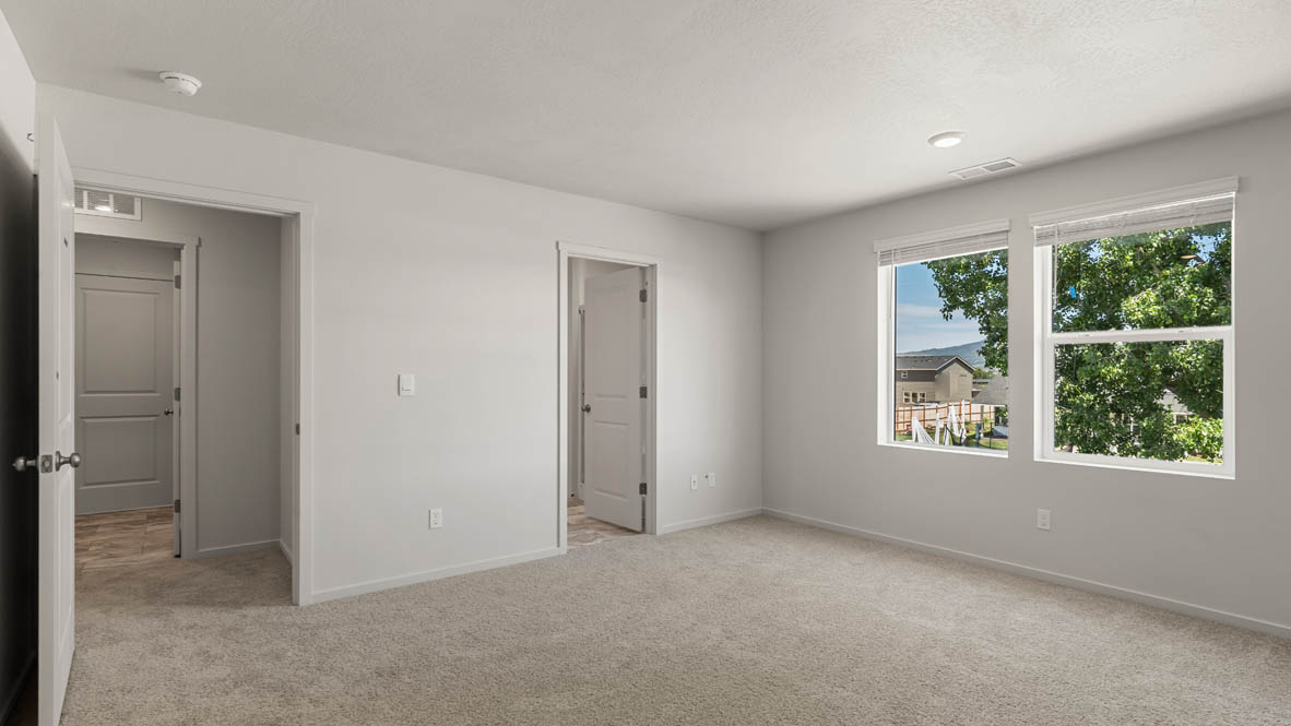 Addysen Park Primary bedroom with white walls, carpet, and door to the hallway
