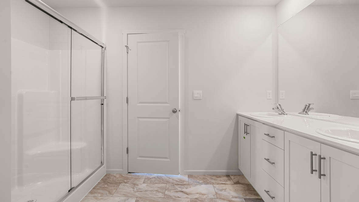 Addysen Park Primary Bathroom with double vanity, walk in shower with sliding glass door, quartz countertops, mirror