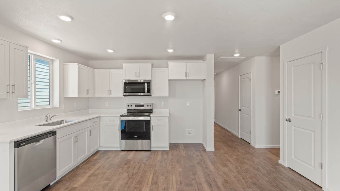 Addysen Park Kitchen with flooring, stainless steel appliances, quartz countertops, and a window