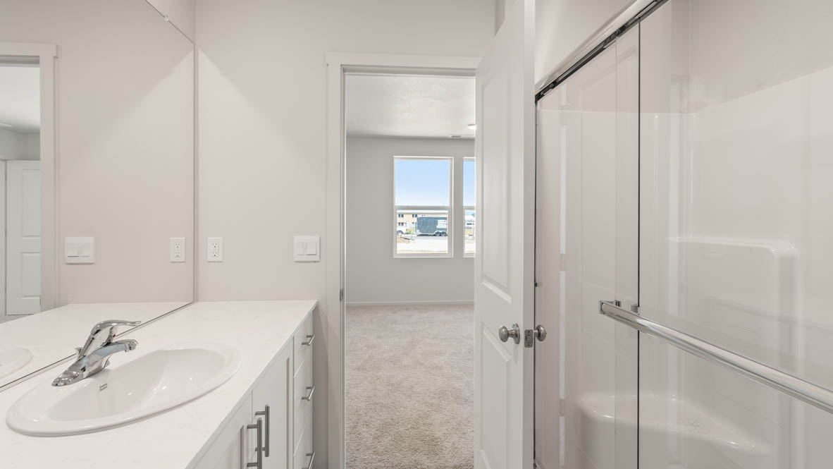 Addysen Park Primary Bathroom with double vanity, walk in shower with sliding glass door, quartz countertops, mirror