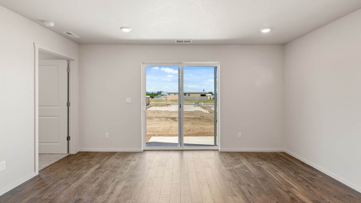 Addysen Park Great room with white walls, sliding glass door, windows, and laminate flooring