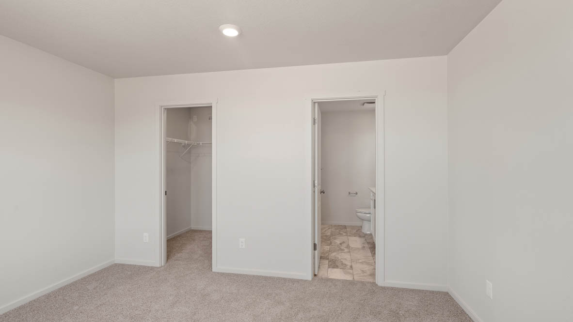Addysen Park Primary bedroom with white walls, carpet, and door to the hallway
