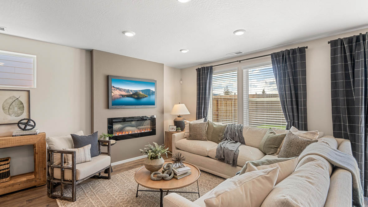 Addysen Park great room with an electric fireplace, couches, coffee table, windows, blinds, and flooring