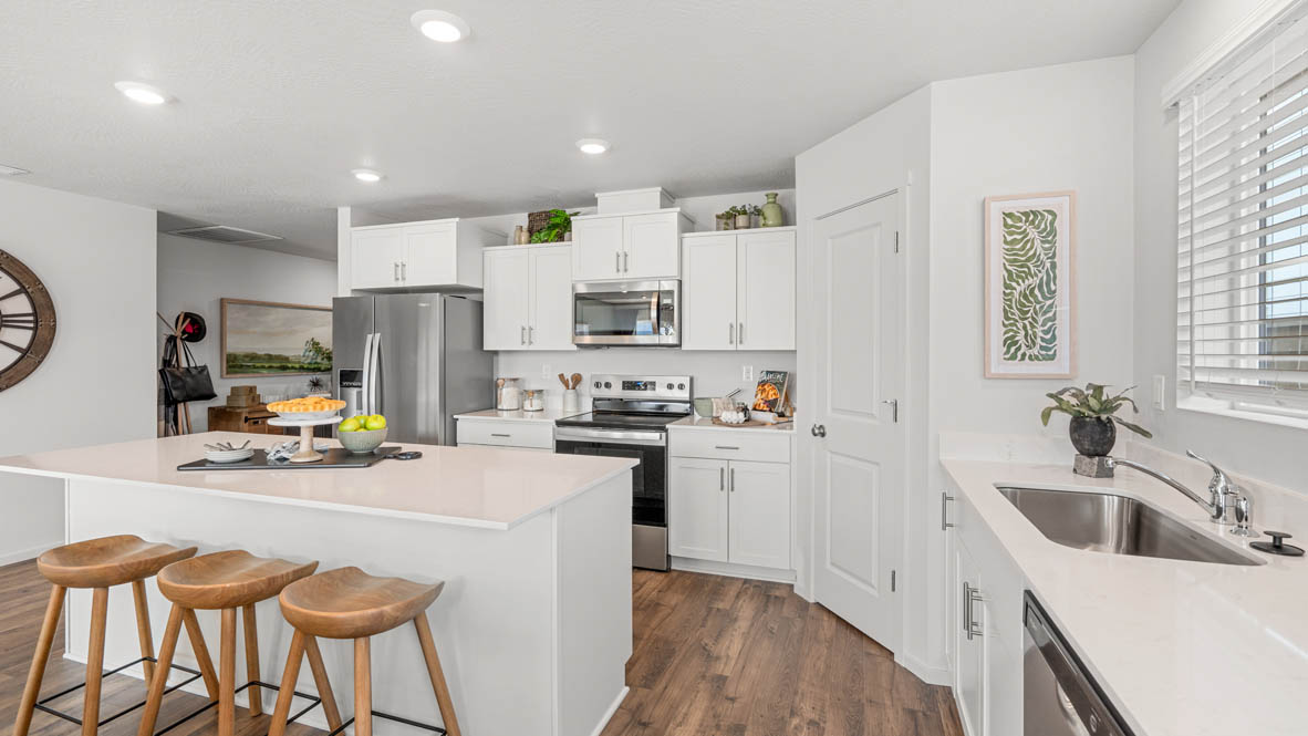 Addysen Park kitchen with stainless steel appliances, white quartz countertops, shaker style cabinets, flooring, a window, and a pantry