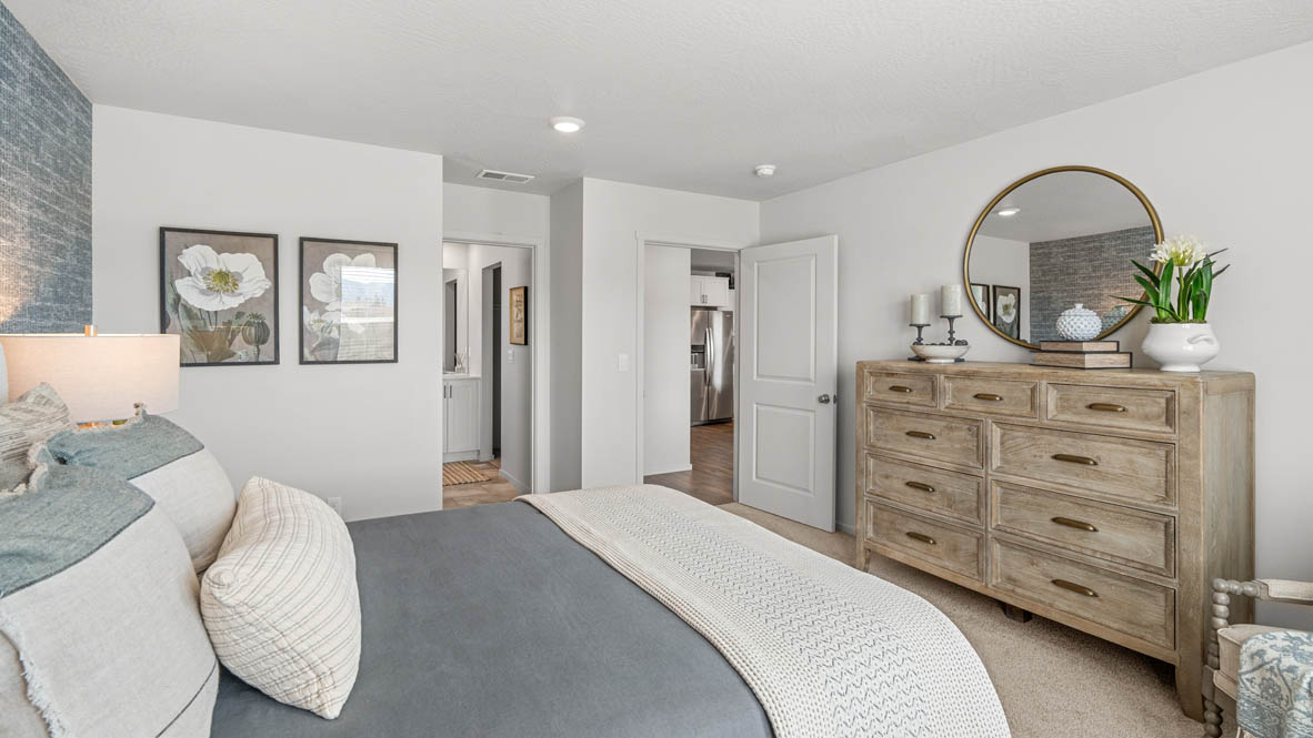 addysen park primary bedroom with blue accent wall and white walls with light wooden furniture