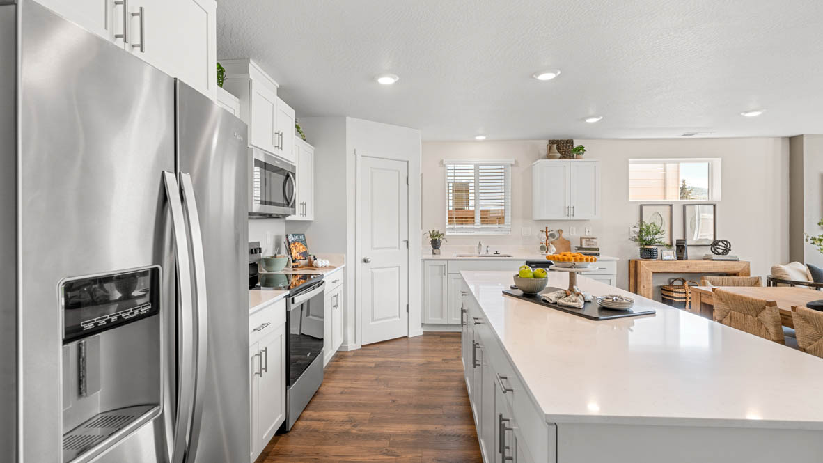 Addysen Park kitchen with stainless steel appliances, white quartz countertops, shaker style cabinets, flooring, and a pantry
