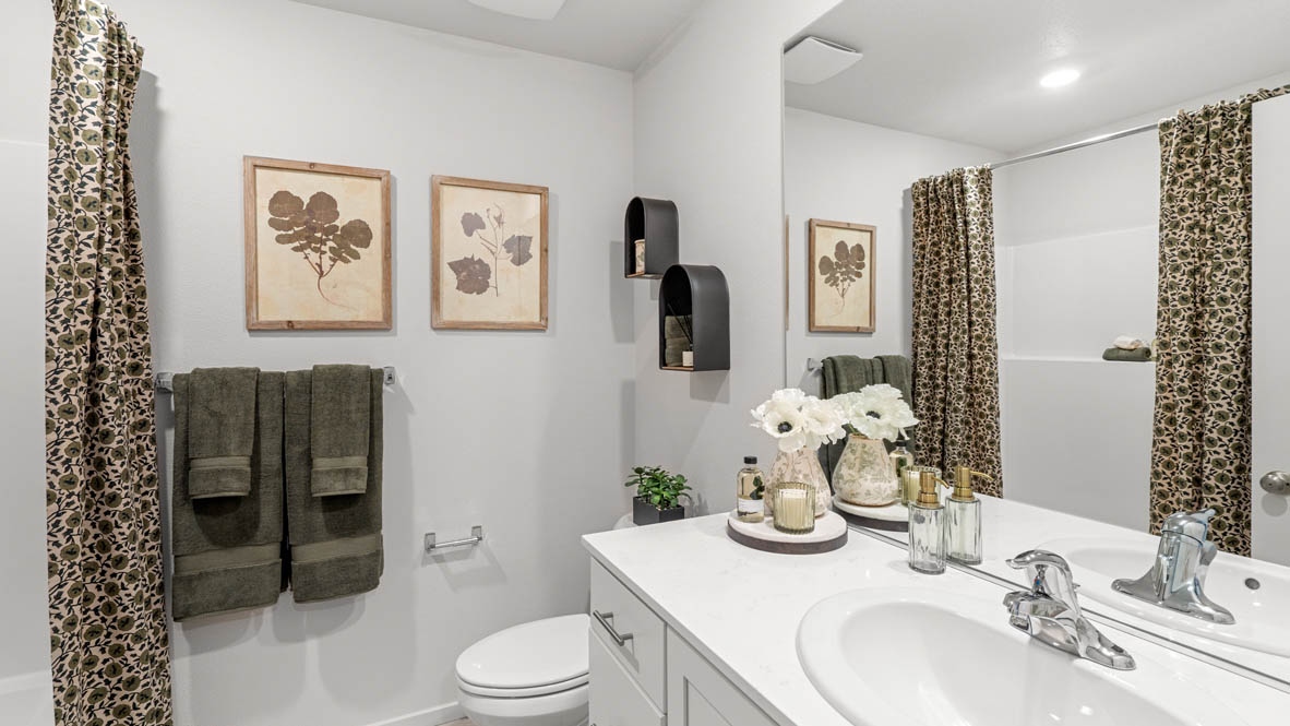 Addysen Park secondary bathroom with vanity, decorative art, mirror, quartz countertops, toilet