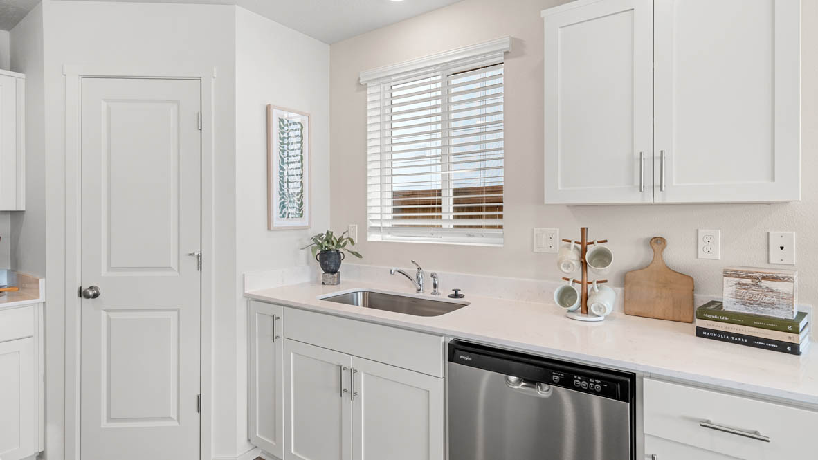 Addysen Park kitchen with stainless steel appliances, white quartz countertops, shaker style cabinets, flooring, a window, and a pantry