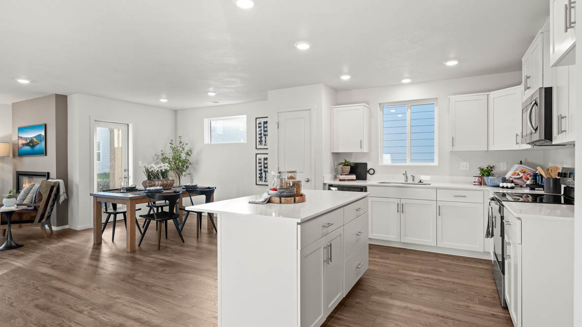 Addysen Park kitchen with island, quartz countertops, and the great room and dining in the background