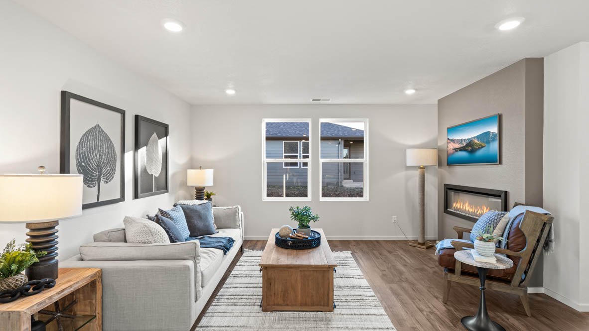 Addysen Park great room with an electric fireplace, couches, coffee table, windows, blinds, and flooring